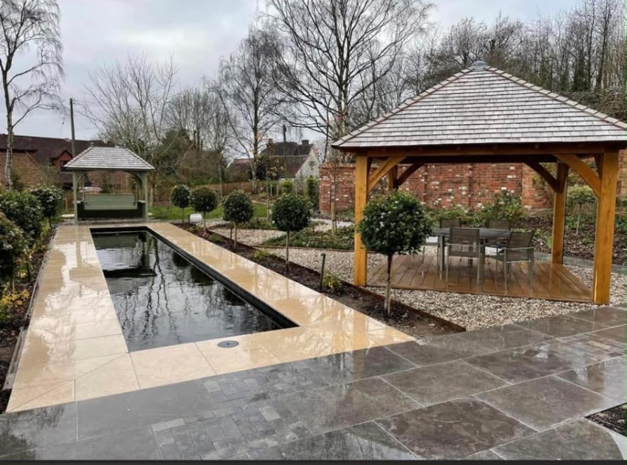 Large landscaped garden with a reflecting pool, natural stone paving and timber pergolas