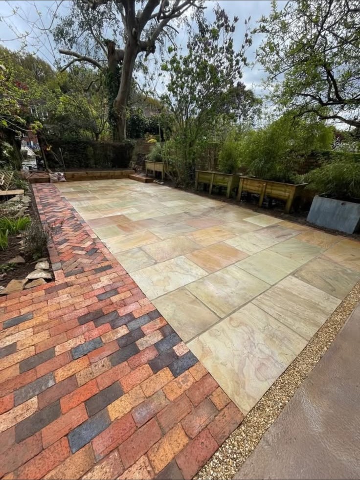 Natural stone patio with a decorative brick path built by RBL Landscapes