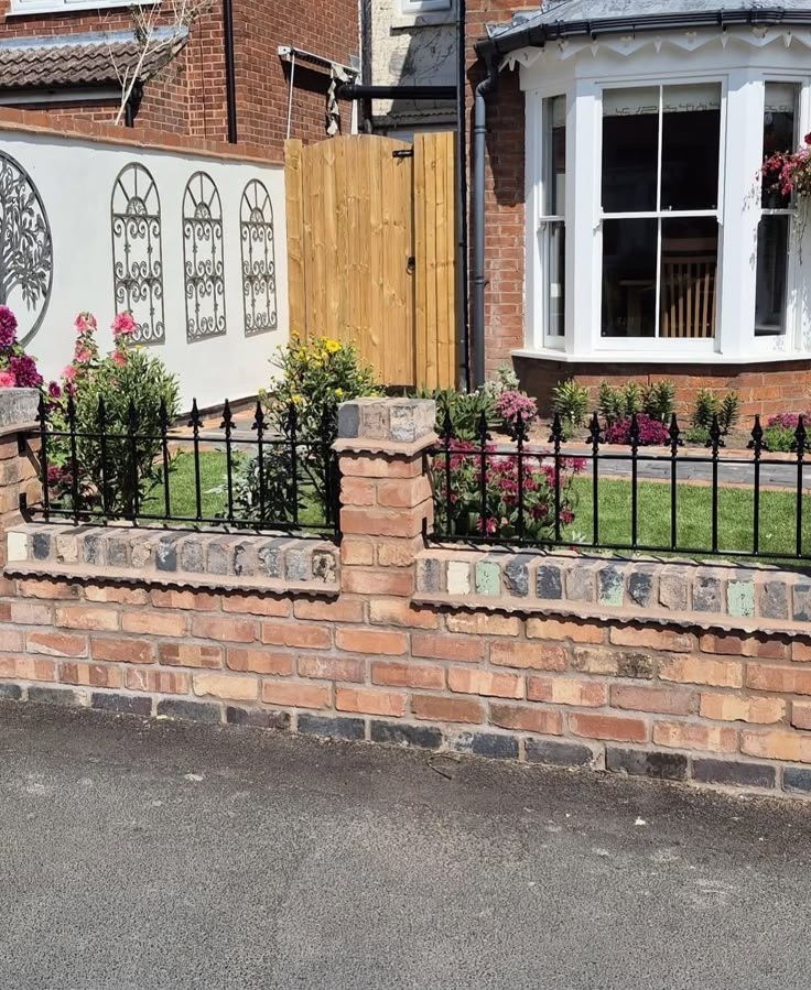 Brick wall with wrought iron railings to a front garden