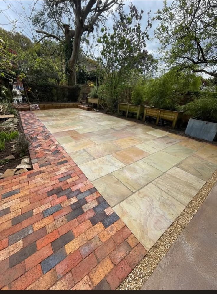 Travertine effect porcelain patio with railings and lawn