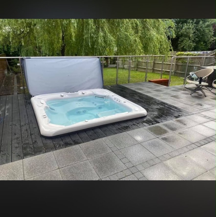 Hot tub set into composite decking beside paving